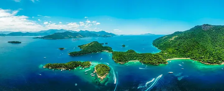 Panorama aéreo de baía com ilhas cobertas de mata e mar azul